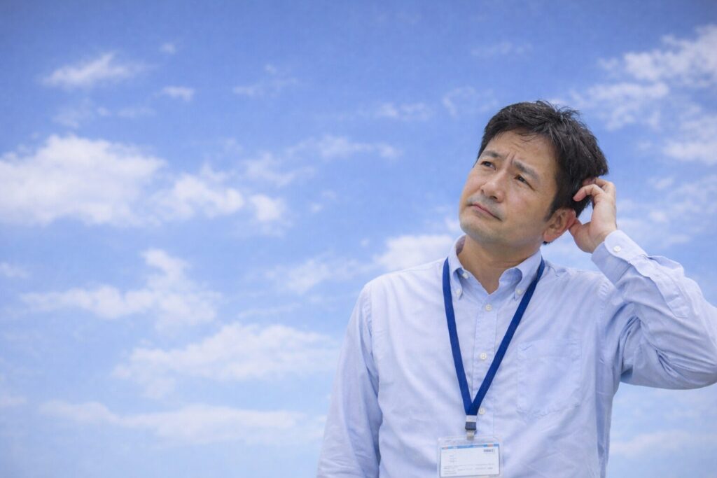 地域集客や地域SEOについて考え込み、空を見上げる学習塾経営者の様子